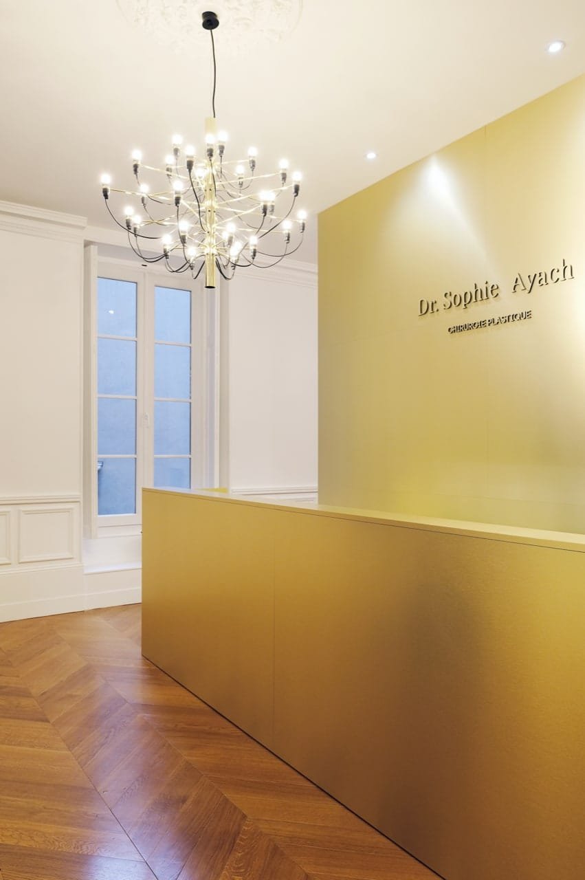 Banque d'accueil sur mesure en finition dorée dans un cabinet médical