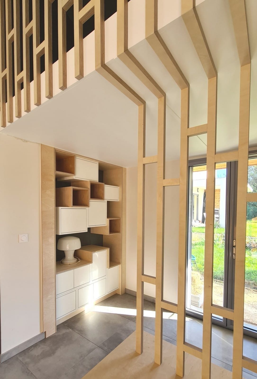 Claustra en bois et bibliothèque à niches asymétriques sur mesure