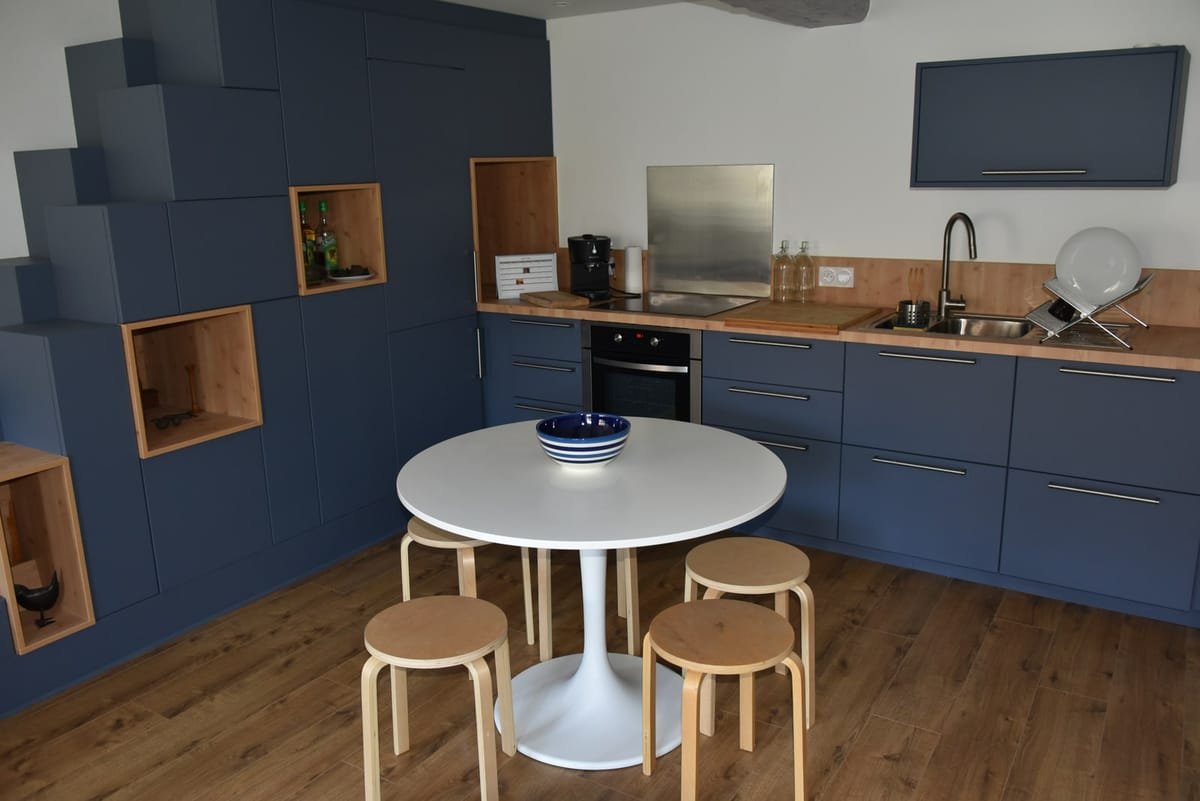Cuisine sur mesure modernisée avec îlot, escalier japonais et niches bois